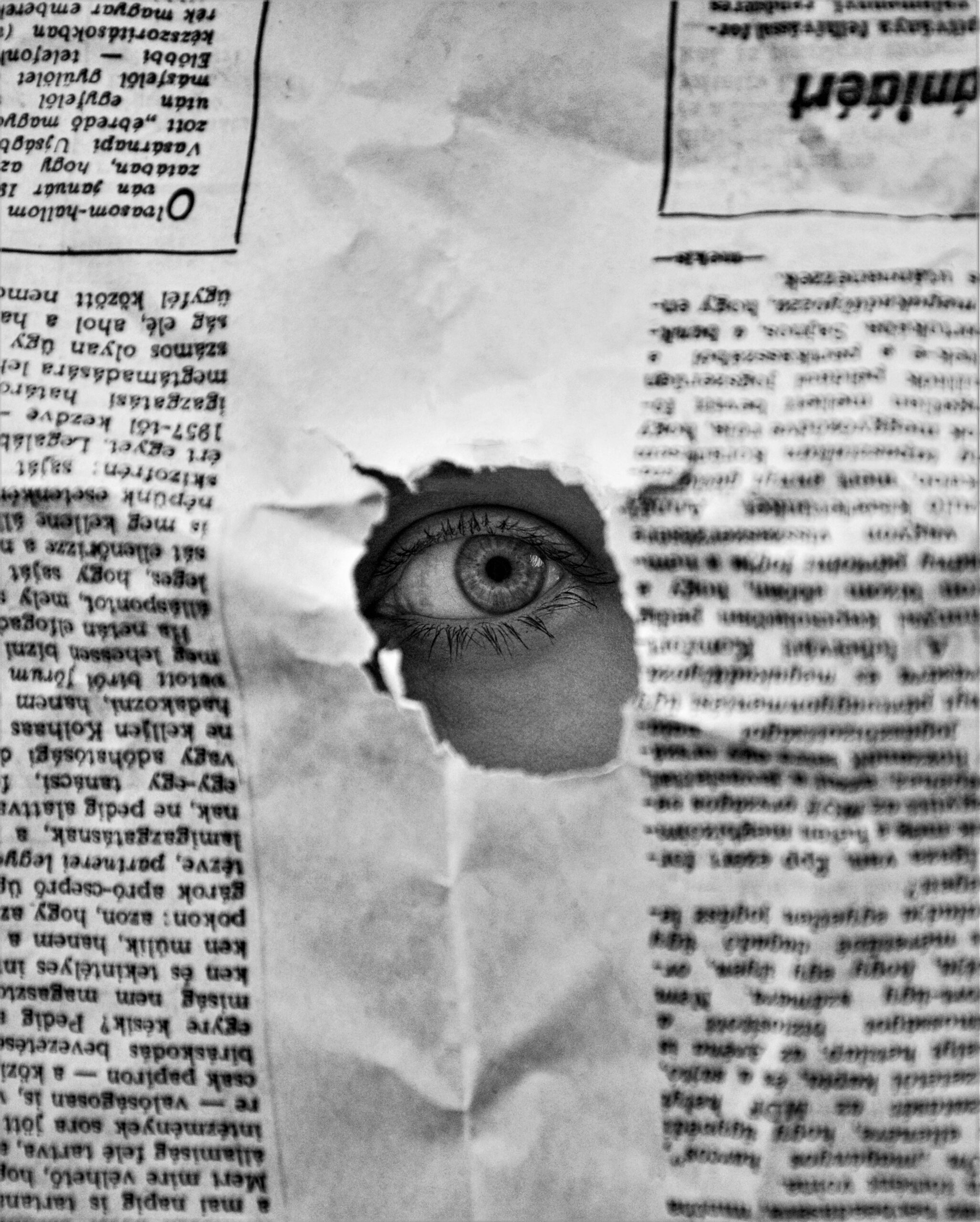 A man stares through a newspaper