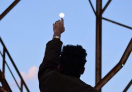 a man reaches up to the sky steel beams surround him